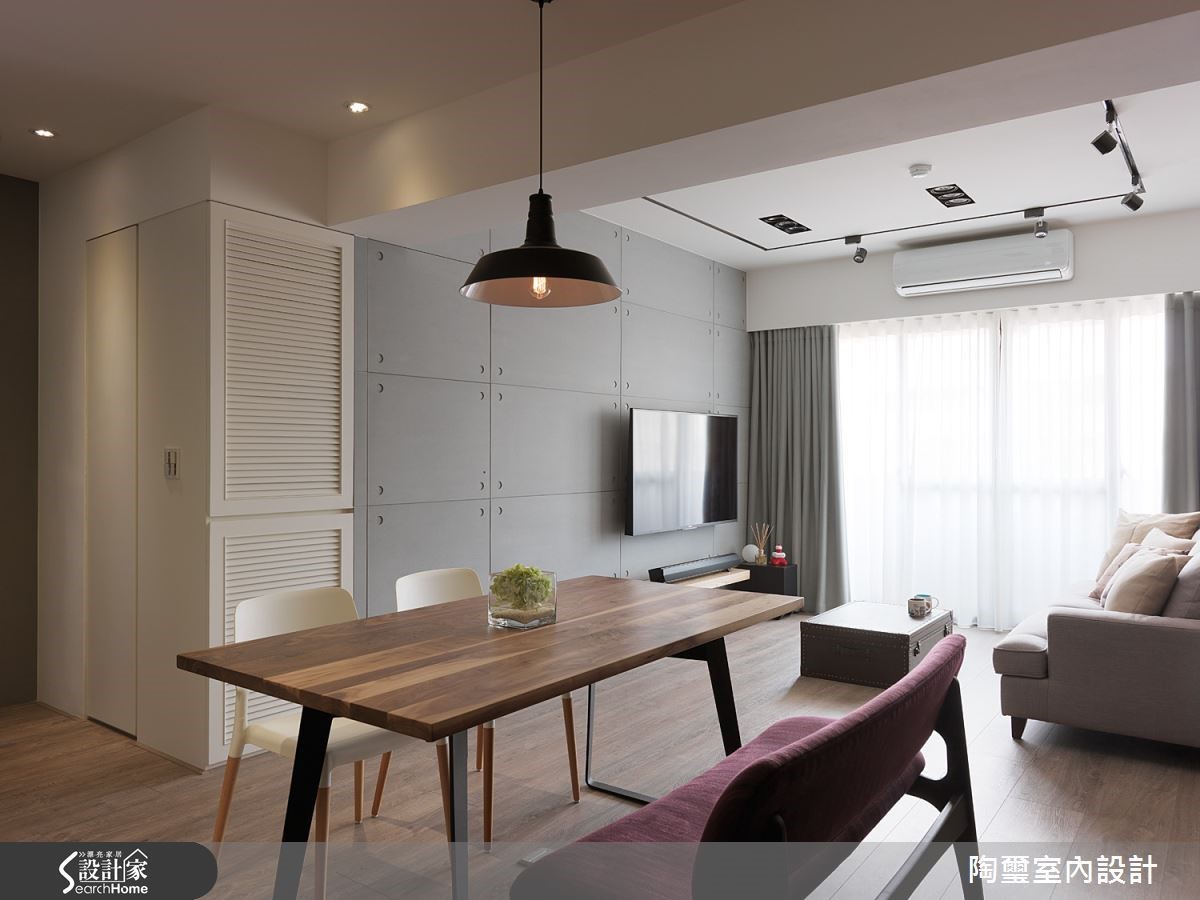 客廳電視牆面的設計可是暗藏玄機！設計師將臥室門口改朝向客廳方向，並且以水泥板材質打造門片，使之與牆面合而為一；而白色百葉後方則是雜物收納櫃，讓畸零空間得到最有效的利用！