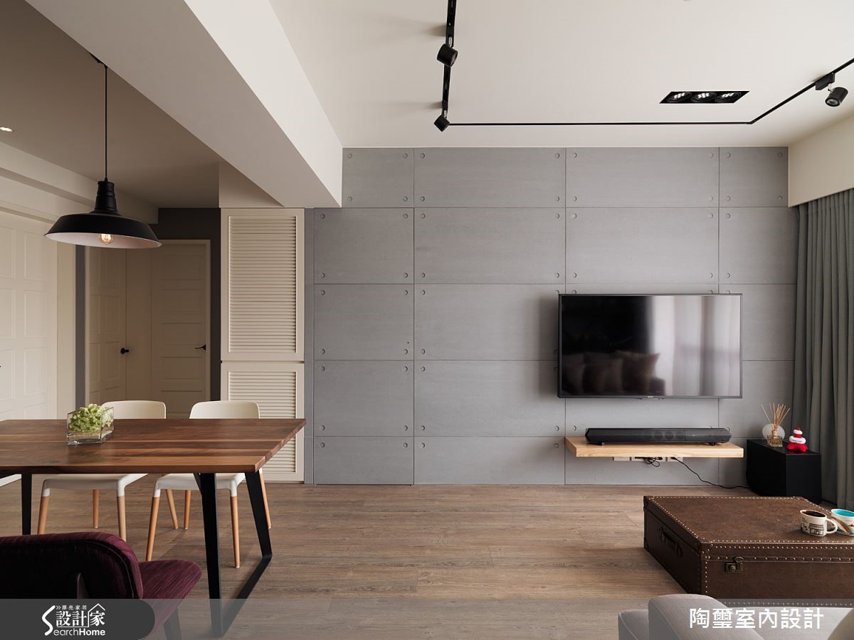 電視牆面以淺灰色水泥板打造而成，簡單俐落勾勒出細膩個性。