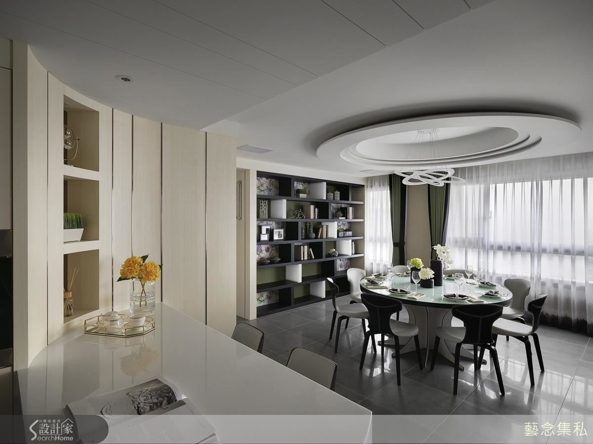 沿著消弭大樑的斜面天花,連接餐廳多層次圓頂佐現代感燈具,向下搭配訂製黑色皮革側邊的圓盤餐桌,彰顯大器都會氛圍。圓弧中島與展示櫃發揮空間坪效加乘展示功能。 沿著消弭大樑的斜面天花,連接餐廳多層次圓頂佐現代感燈具,向下搭配訂製黑色皮革側邊的圓盤餐桌,彰顯大器都會氛圍。圓弧中島與展示櫃發揮空間坪效加乘展示功能。