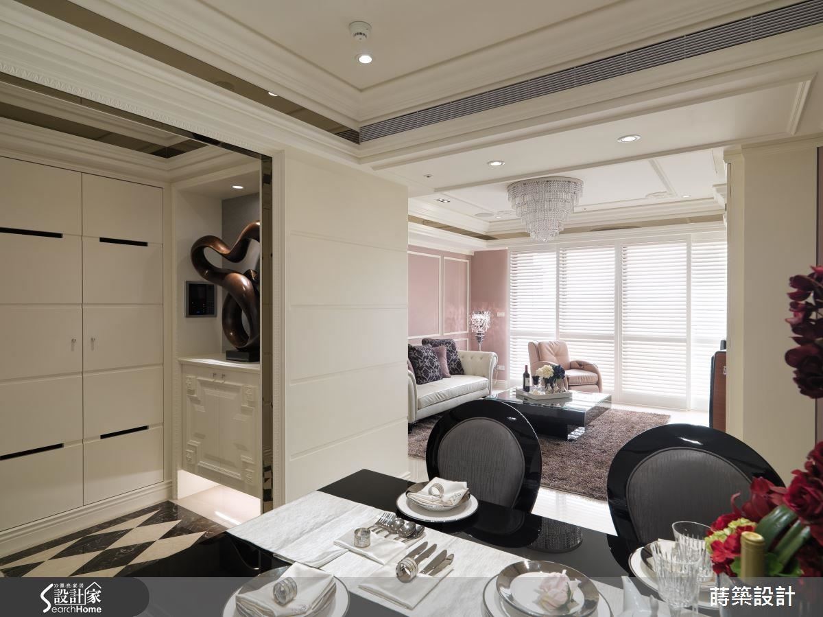 原本建商規畫的空間沒有玄關，但考量空間足夠，也希望做出使用區隔，於是利用雙面櫃隔出玄關，整牆的白色鞋櫃以內凹的溝縫做出線條，黑色部分則是通氣孔，玄關櫃則以線板做出造型。