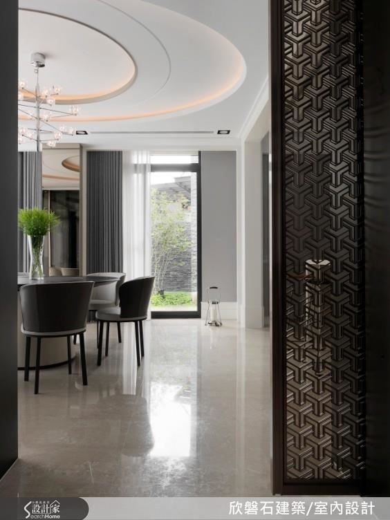 餐廳與客廳空間位於同一條軸線以穿透的電視牆與鈦金雷射切割格柵電動門區分，構成便利動線，雙面以大理石、鈦金屬與玻璃異材質銜接，整合展示收納，滿足兩個場域的雙功能性。