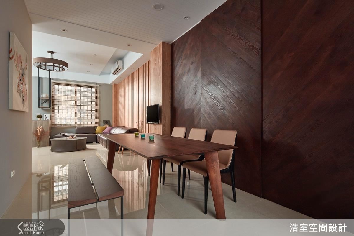 公共空間的主牆以染色的栓木實木貼皮裝飾，但顏色及排列方式做出變化，餐廳部分染成深色，做出人字形對花，豐富空間的層次感，也有穩定氛圍作用。