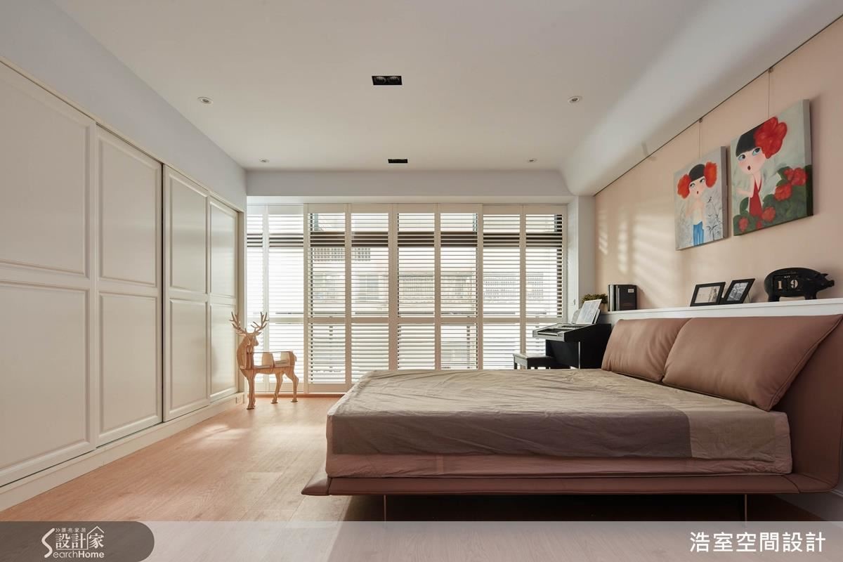 2 樓的長輩房空間相當寬敞，但因為與鄰居的棟距沒有太大，開窗時可以看到對面鄰居，在顧及隱私及視覺美觀的前提下，利用實木百葉裝飾原本的落地鋁門窗，不必另外拆窗，就一舉解決問題。