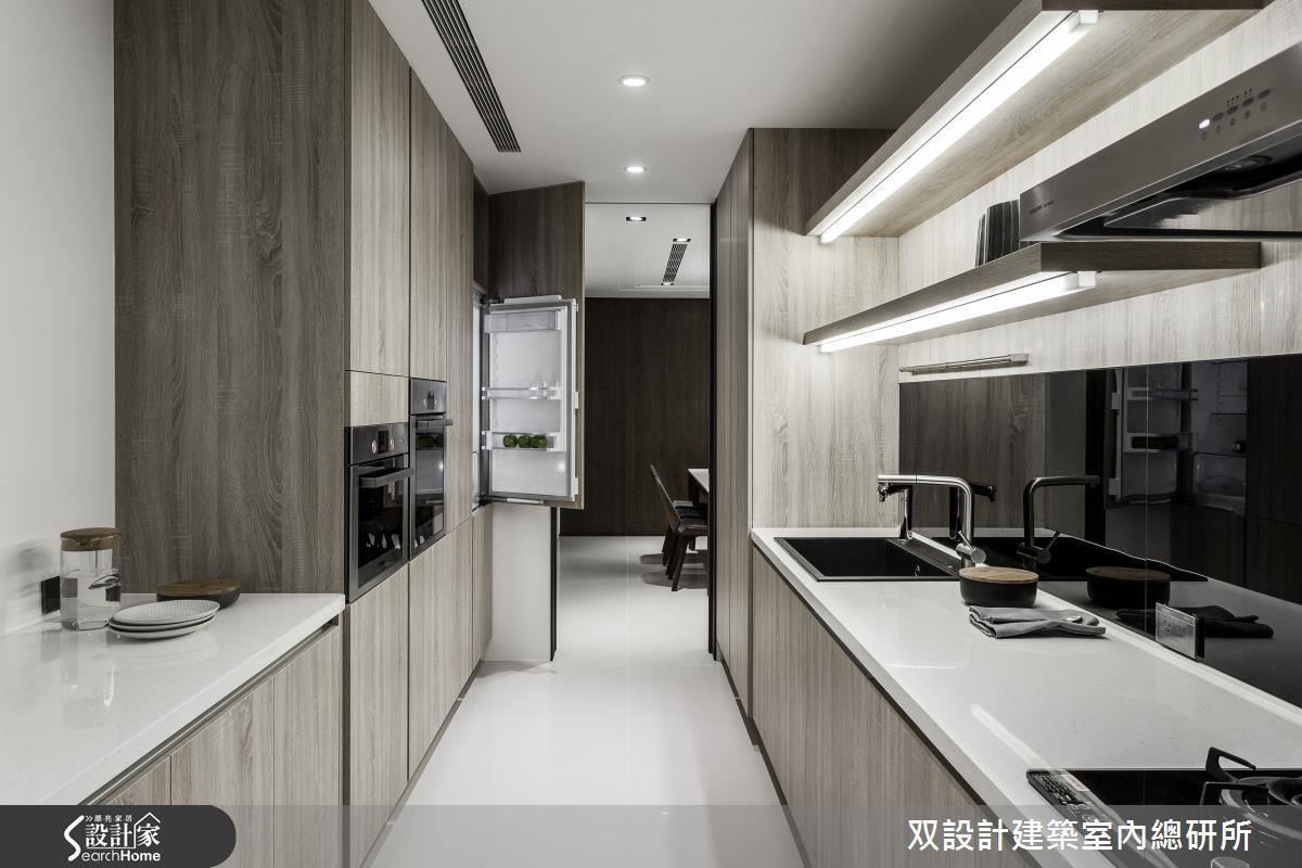 長型廚房的面積有限，將冰箱等家電全藏在入口兩側的櫃牆立面內，能創造出極高的收納效率。圖左的矮櫃，檯面還可充當備餐檯、擺放剛出爐的菜餚或等待下鍋的備料。