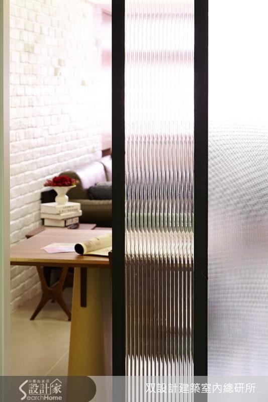 從廚房往餐廳、客廳看，這道拉門利用條紋玻璃透光卻不透視的特質，製造出曖昧的界線。