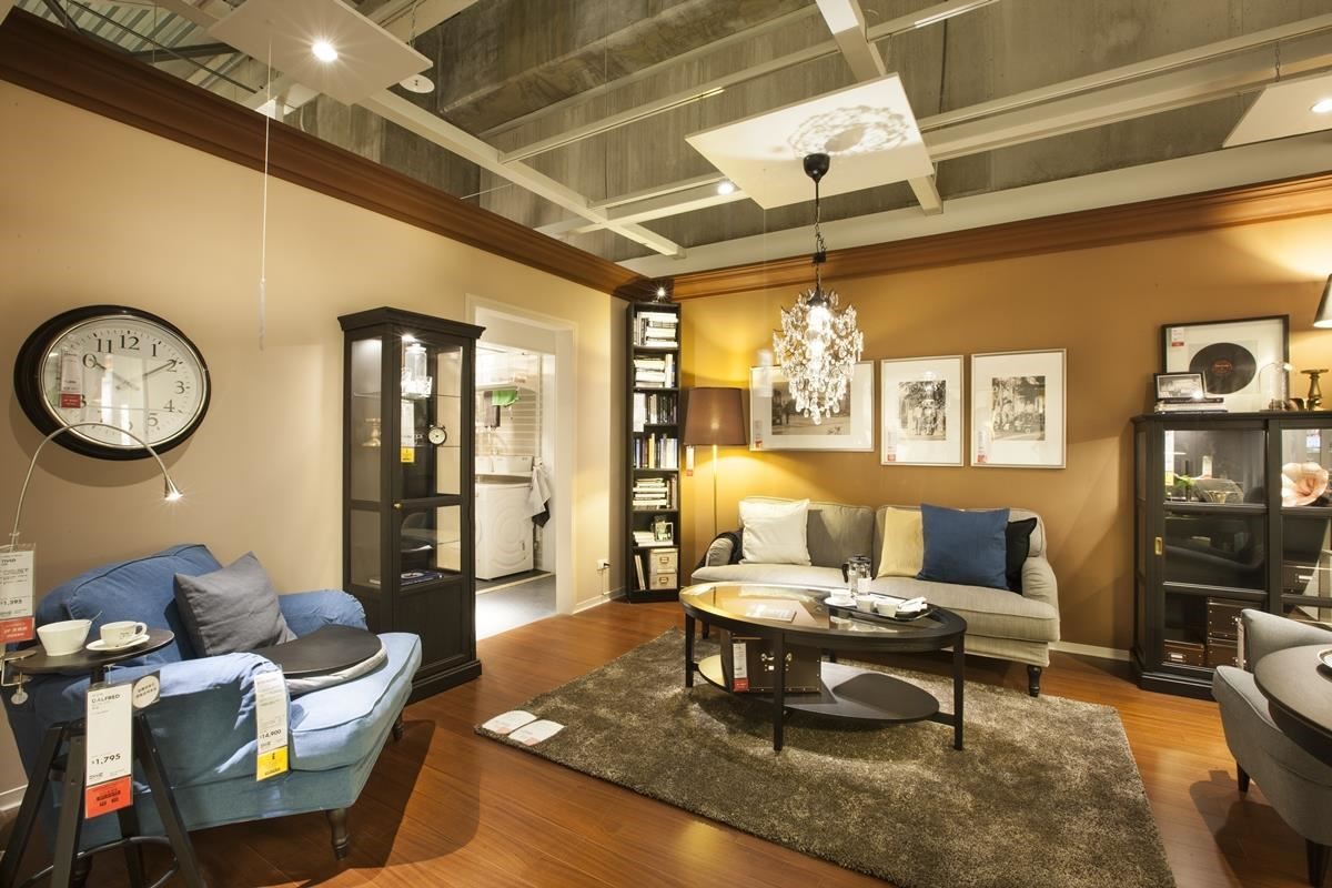 開放式儲物櫃兼具收納與展示，規劃不同收納櫃和沙發桌椅，一方面滿足退休長輩收藏書籍和旅遊品的需求，另一方面選擇的單人扶手椅與茶几，則符合成年兒子工作的需求。