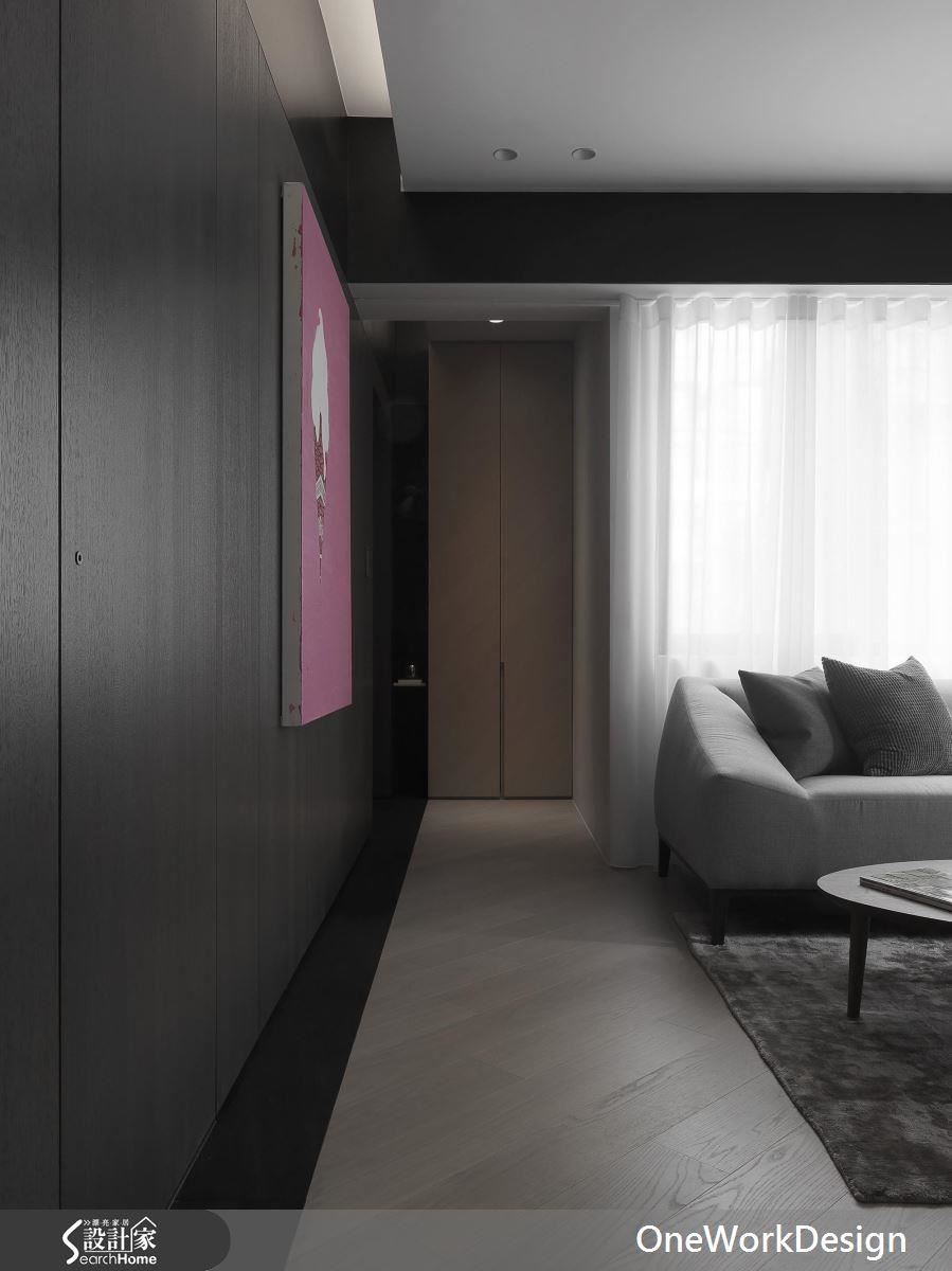 從大門進入的玄關區、廊道旁的大面積立面中，安排了收納櫃、隱藏了廁所門，留給客廳完整乾淨的空間，視覺不被干擾看起來更寬闊。