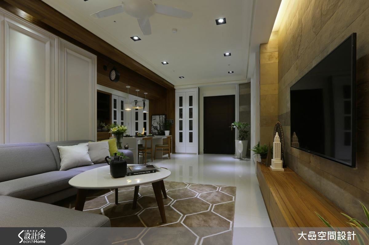 將空間巨大的樑體，以木皮包覆潤飾，並將材質延伸至客廳沙發背牆，形成一幅如畫一般的框景。