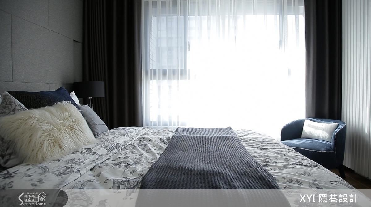 主卧延續簡潔明亮的風格，床背牆以布紋質感的灰磚構成俐落，櫃體則呼應空間中的線條語彙。