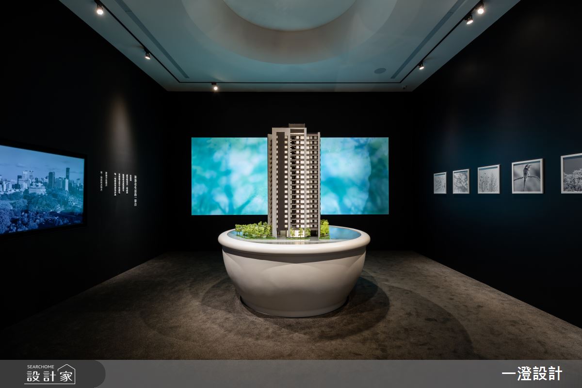 黑色立面與投影布幕結合聚光燈，使建築模型展示更具戲劇張力，也能滿足會議的投影需求。