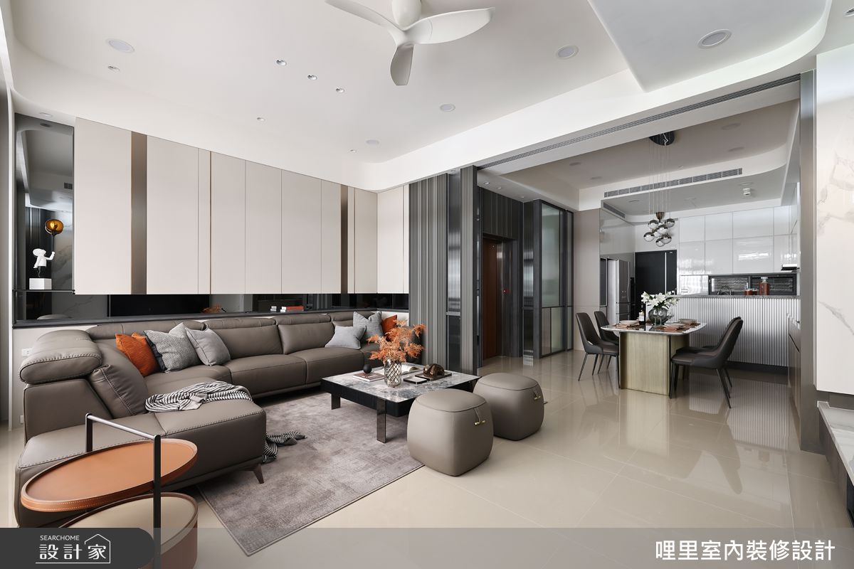 客廳沙發背牆採用大面積系統櫃,搭配鍍鈦飾條和氛圍燈條,齊背高度的平台設計整合插座,提供了極佳的取用便利性。
