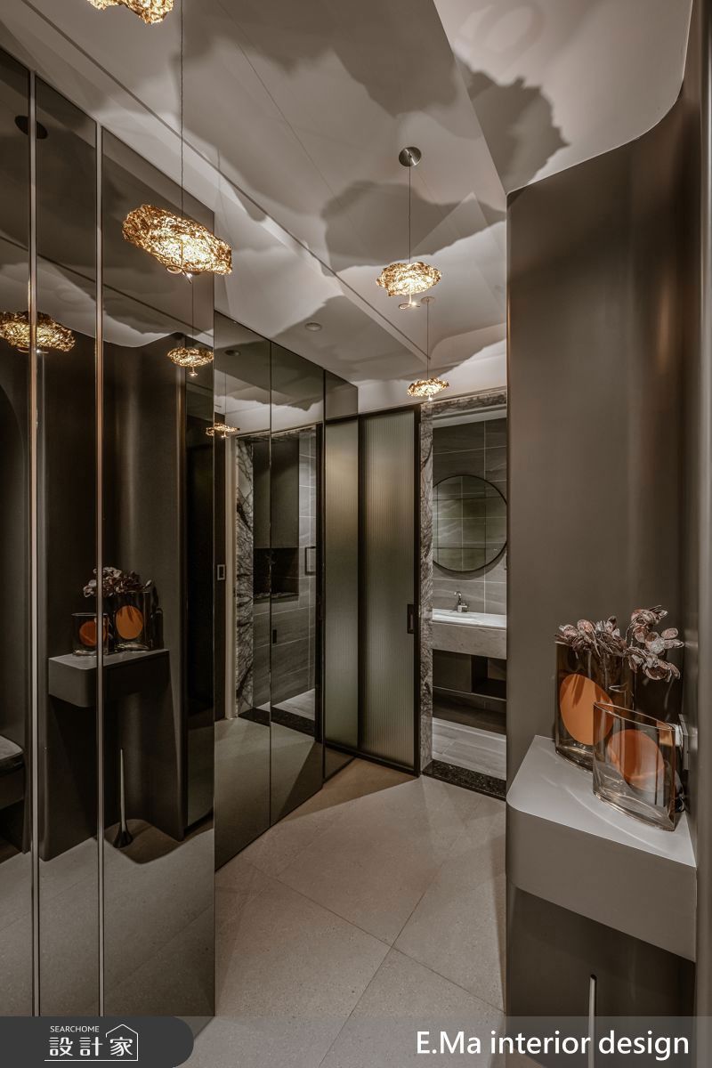 玄關鏡面加上玻璃,一道一道的揭開,即使隱藏的小客用衛浴,也能藉灰階材質與柔光塑造私密又溫潤的氛圍。
