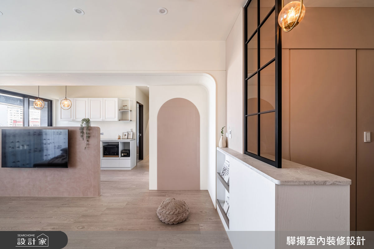 玄關透過俐落門片，隱藏儲藏室，滿足收納機能；客廳的粉色磁性烤漆玻璃牆面，既增添視覺亮點，又提供孩子塗鴉的互動區。