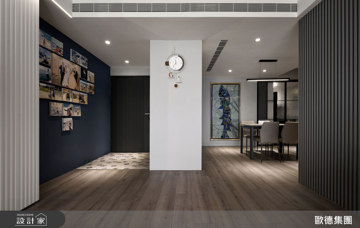 玄關鋪設SPC木地板，搭配雙面櫃串聯餐廳形成回字動線，兼具收納與場域劃分。
