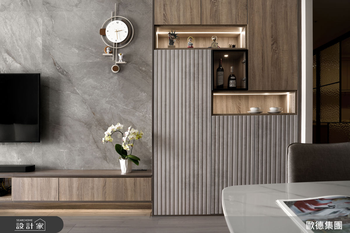 深木紋系統櫃貫穿公領域三面動線，結合鏡面、格柵與燈條設計，消弭厚重感並增添層次。