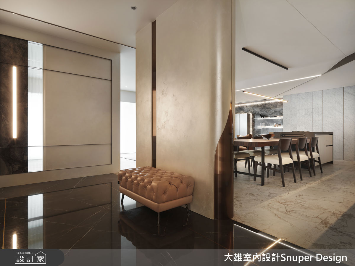 玄關設計是一大亮點，牆面邊緣以女性高跟鞋後跟般的優雅曲線收邊，象徵回家儀式感的柔性力量，為空間增添藝術性的細節。