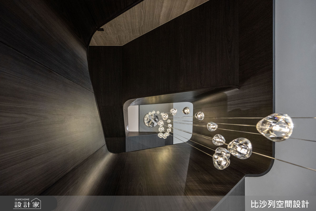 梯體曲面盤旋而上，如藝品雕塑般的美感佇立於空間中，映照著光影流轉，成為廊道動線中的視覺焦點，書寫關於家宅的記憶。