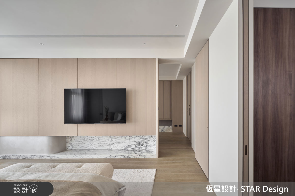 主臥以白色基調貫穿全室，搭配木質調電視牆，注入溫潤氣息。