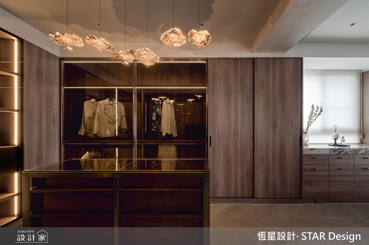 更衣室以木質色系鋪陳，搭配藝術造型吊燈，展現靜謐奢華的氛圍。