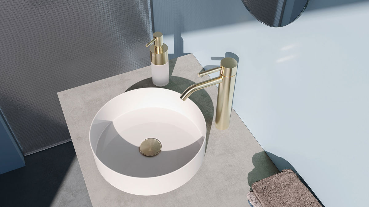 Dornbracht META金色龍頭以俐落圓柱線條佇立檯面，在冷灰石材與霧藍牆面間形成和諧的對比，。