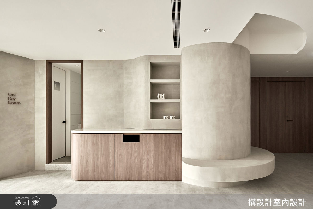 龐大突兀的結構樑柱經由圓弧語彙包覆，並順勢延展出實用的木質收納櫃和半圓形候診座位，化劣勢為亮點。