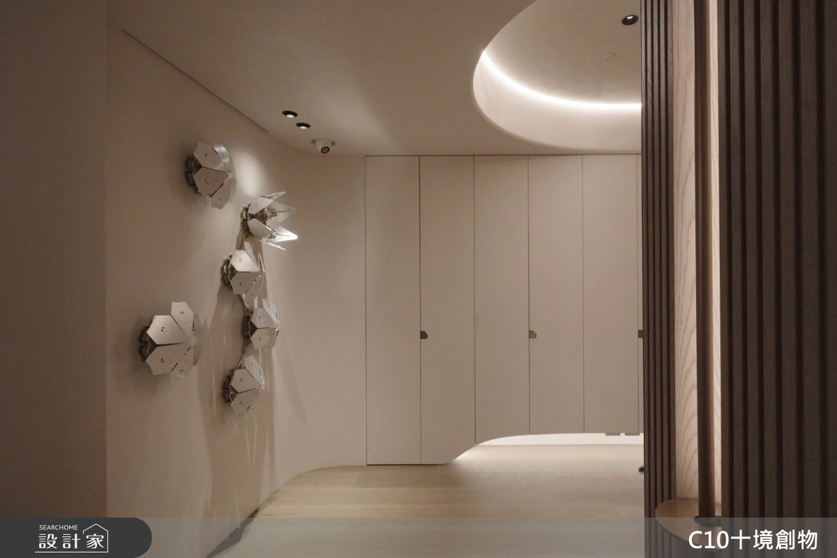 玄關端景採用金屬裝置藝術花，呼應整體空間靜謐沉穩的氛圍。