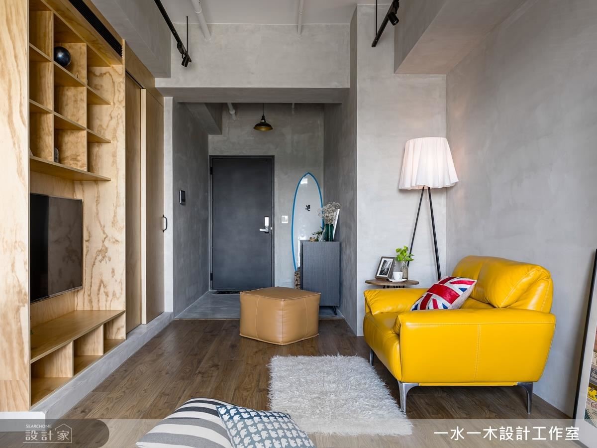 玄關到客廳處，為了強化原先 L 型格局缺點，以一致性材料鋪設牆面，延展空間線條，製造放大視覺感。
