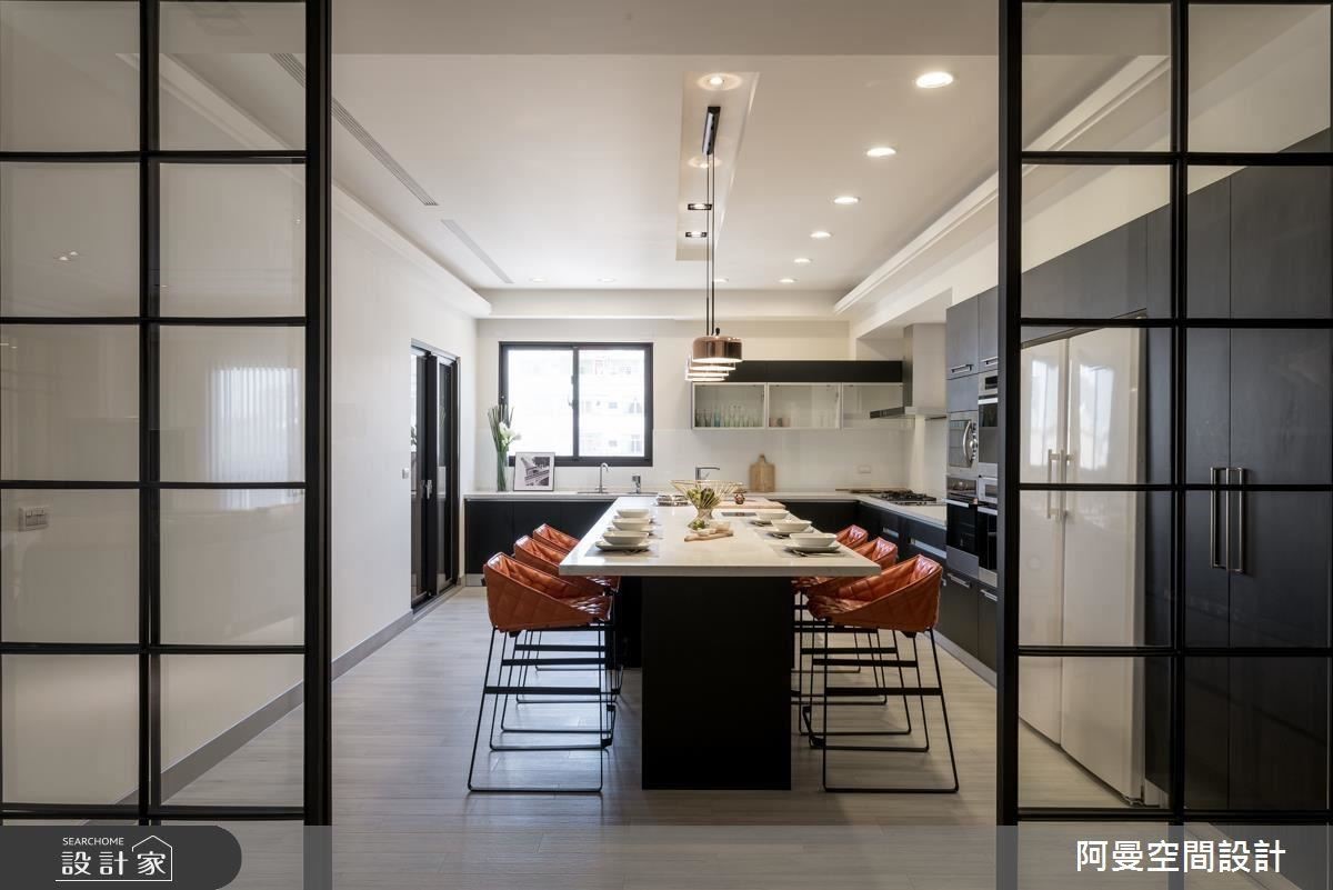 同樣以鐵框玻璃拉門作為空間區隔，一體成型的長桌，兼具中島與餐桌機能，橘色餐椅點亮空間色彩，而石材檯面襯托時尚質感。
