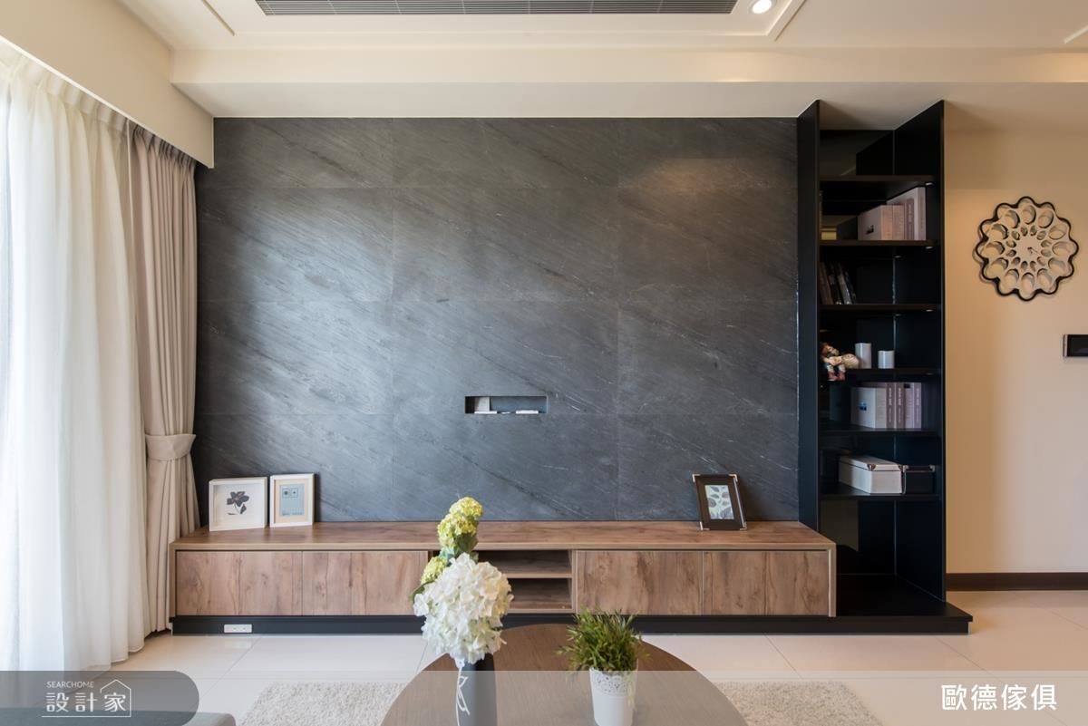 客廳電視牆面選用細緻灰色薄石板，延續空間調性，引入沉穩內斂感。