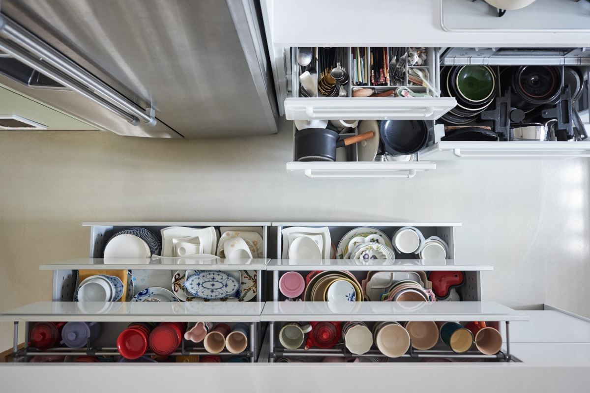 餐廚壁面使用優雅白琺瑯板，體貼女屋主烹飪需以磁吸固定食譜的需要，同時也配合公領域的自在氣息。開放中島空間則巧妙修飾樑柱問題，並特別於中島賽麗石檯面上下增設鐵件吊櫃及兩側的木作置物空間，給予女屋主滿意的料理創作揮灑平檯。