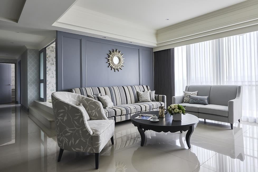 客廳沙發背牆以沉著藕灰色鋪陳，透過軟件花色搭配與金屬飾品點綴，空間自由揮散出美式的休閒舒暢感。