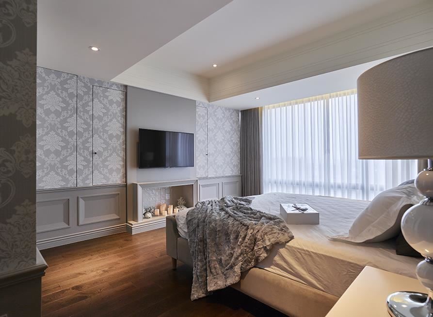主臥空間延續藕灰色調的沉穩，藉線板造型堆疊牆面層次，下方更以國外壁爐造景，替休憩空間增添不少浪漫情趣。