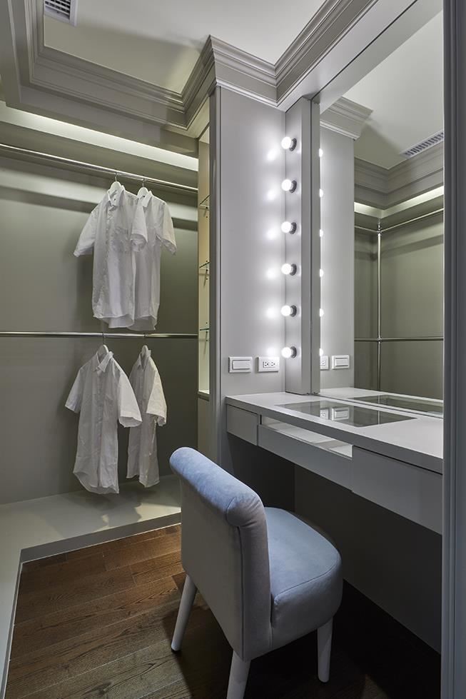 更衣室以雙層收納桿供應四季衣物收整需求，並於一旁安排巨星燈造型梳妝檯，使女主人日日享受生活起居美好。
