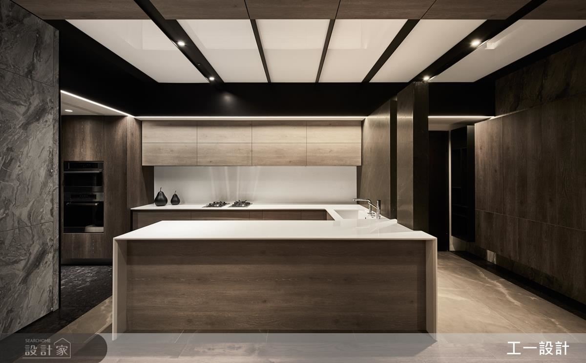 入門玄關右側，以懸浮大理石牆區隔餐廳中島，與一旁懸空櫃體作量體的對應切齊，天花運用壓克力創造充足光源，改善採光不佳的問題。