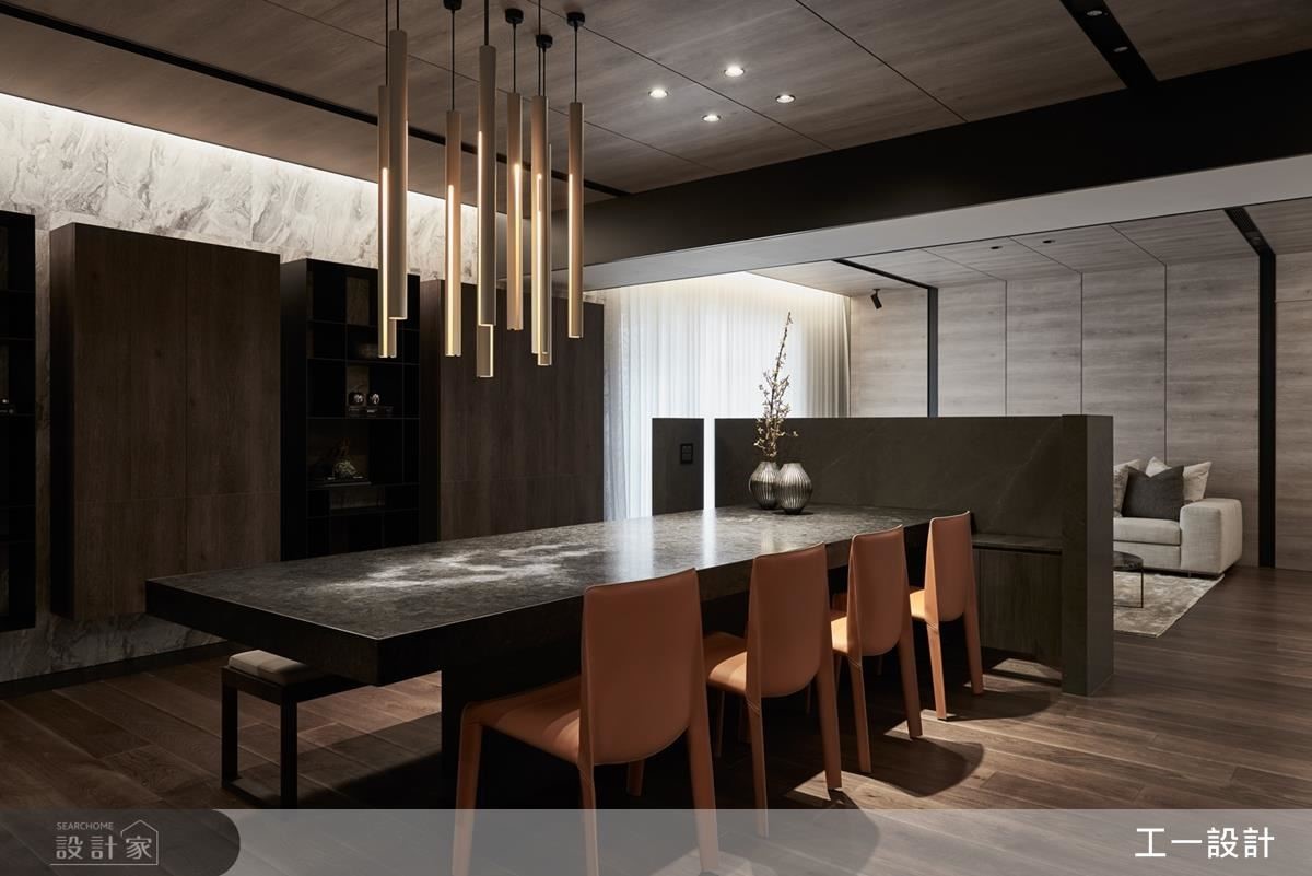 餐桌區結合半高電視牆訂製長型大理石餐桌，創造視覺的延伸，開放式的設計也帶來流暢的生活動線。
