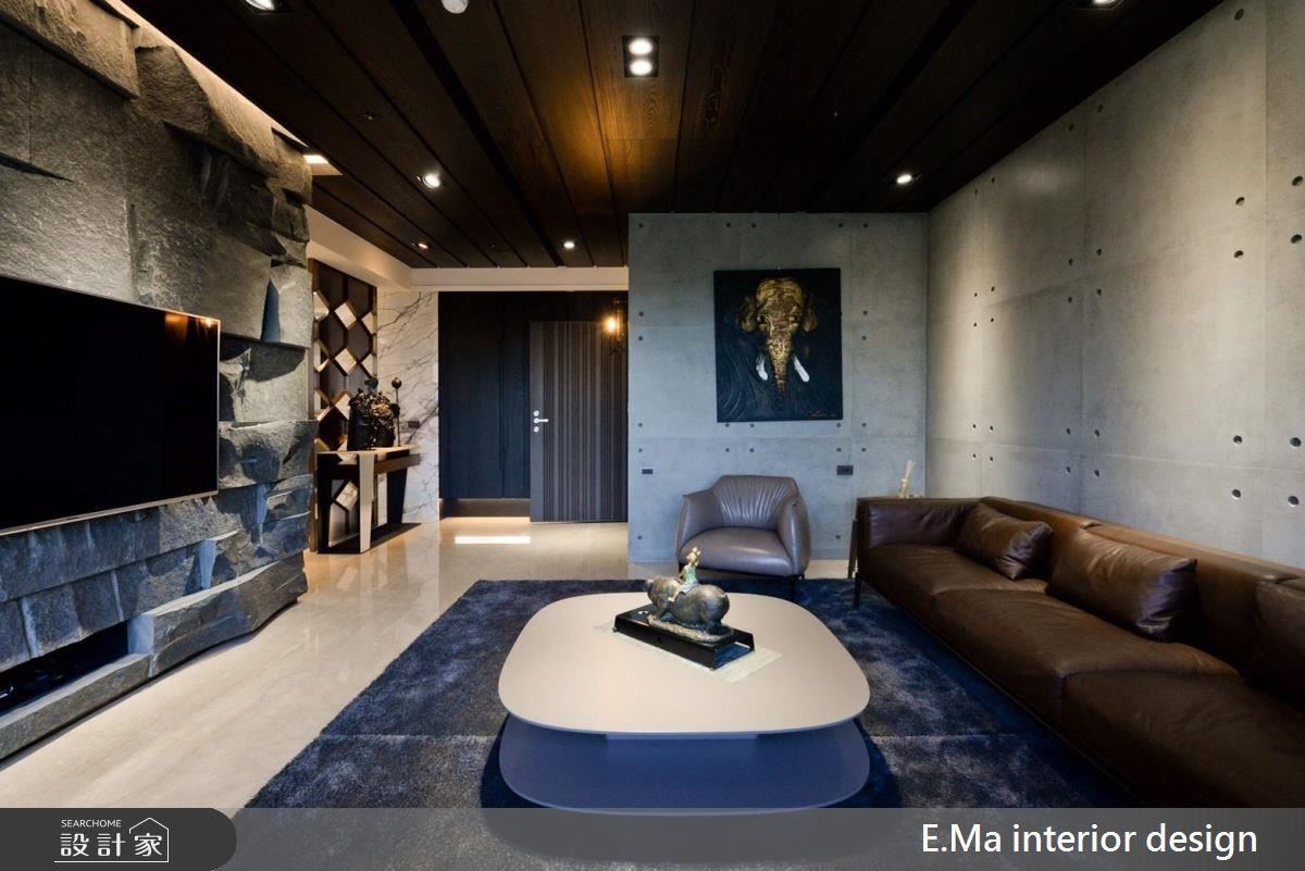 客廳沙發背牆使用清水模打造樸質感，電視牆則選用印度黑石皮，並藉凹凸形狀紋理帶出空間的粗獷層次美。