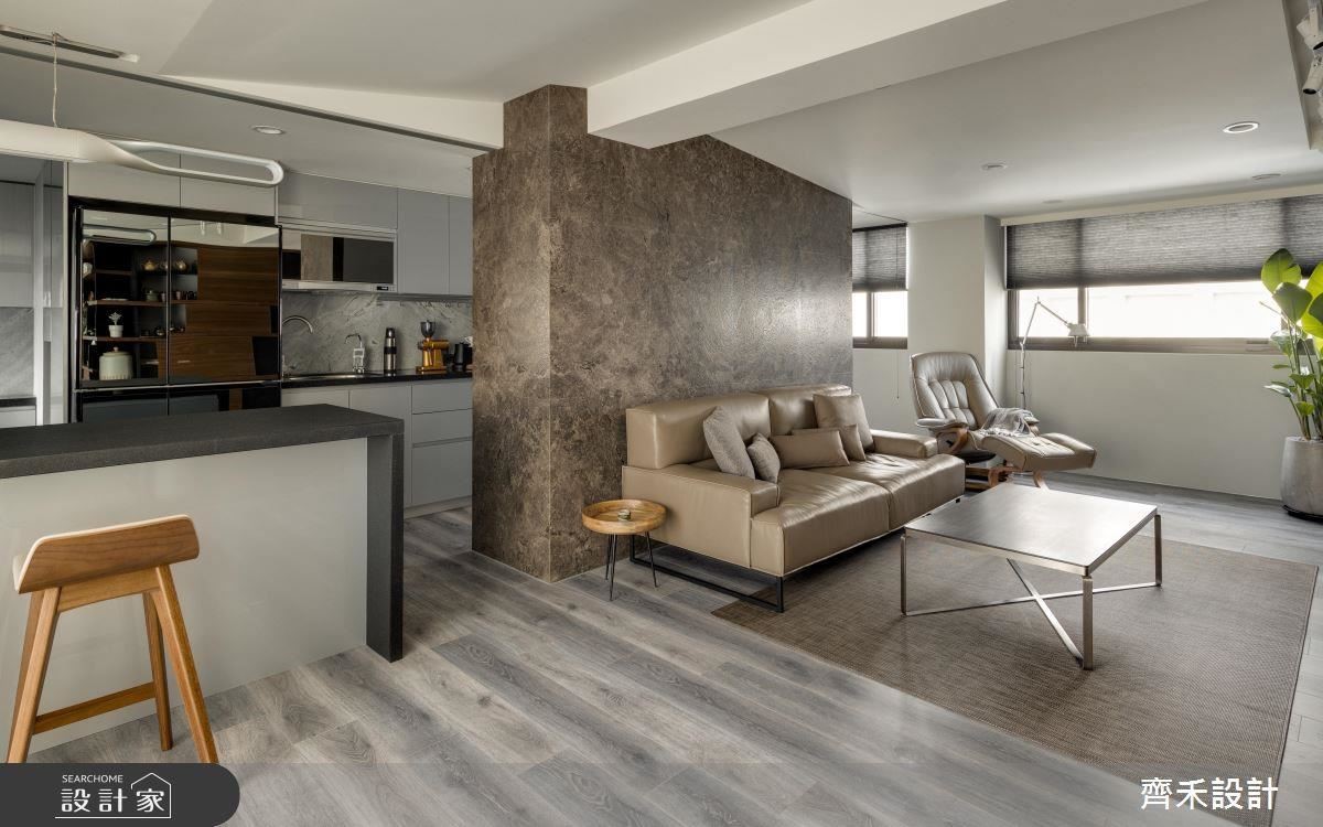 沙發背牆採用火山泥塗料襯托粗獷感，順勢成為客餐廳循環動線的主軸。