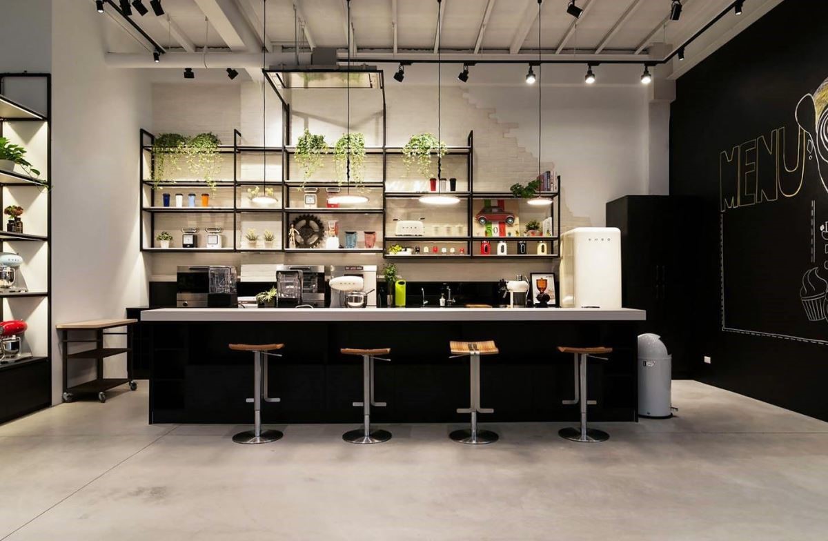 空間裡結合大型吧檯，綠意植物與鐵件的展示層架，傳遞隨興自在的生活態度。