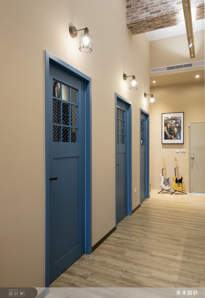 教室門與接待大門的普魯士藍門片相呼應，搭配清爽的土色牆面，產生英倫感的視覺效果。
