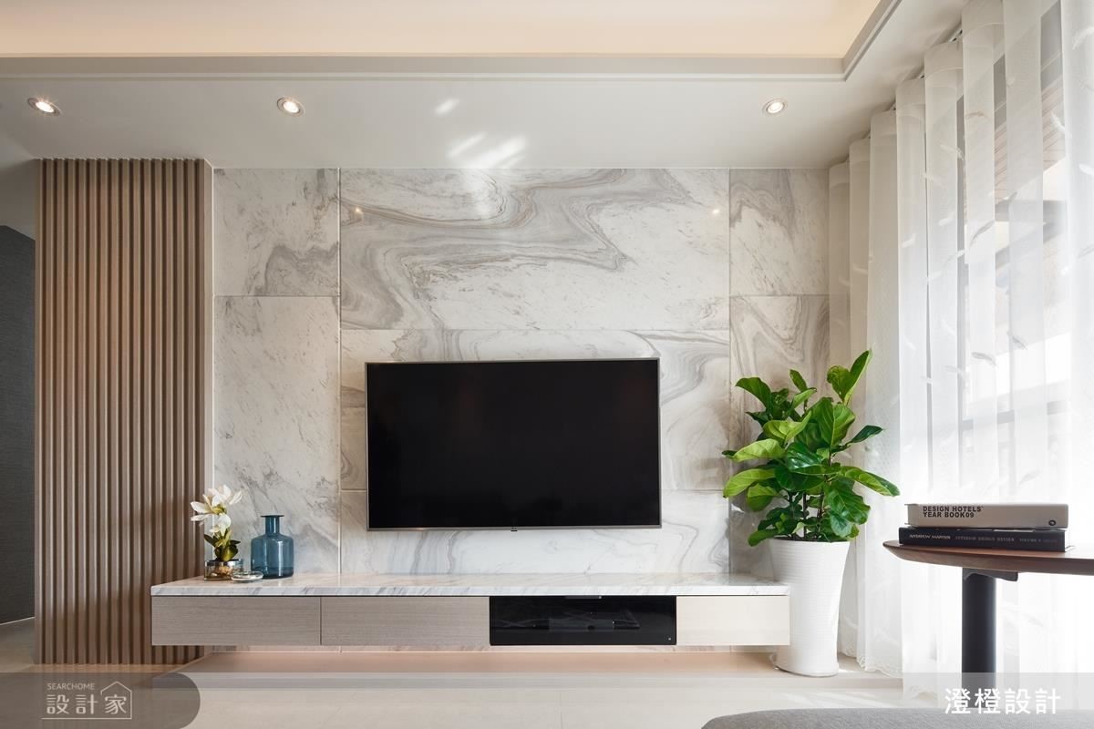 客廳電視牆藉由不對稱銀狐大理石，譜畫現代簡約美感。