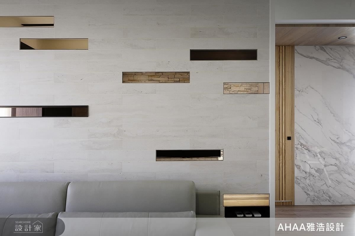 客廳沙發背牆以鏡面點綴於霧面石英磚中，藉由反射效果增添視覺層次。