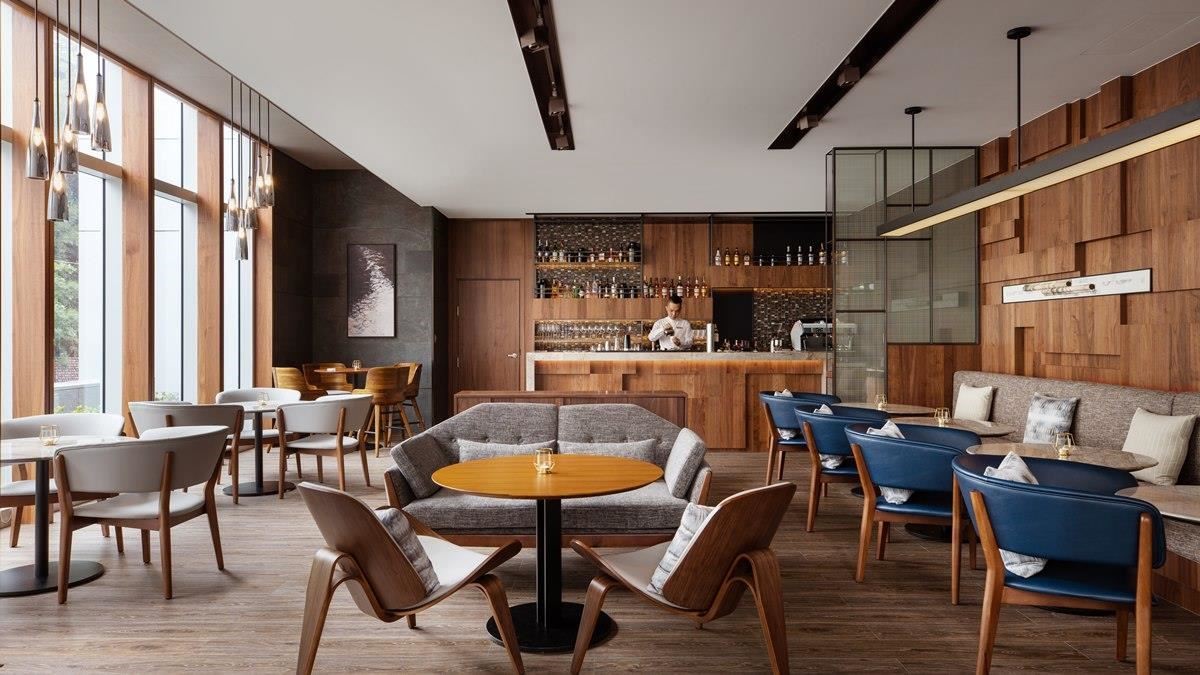 大廳酒吧立面採大面木色包覆，展現放鬆而溫潤的空間氛圍；其中不規則線條更流露現代的雅致風情。
