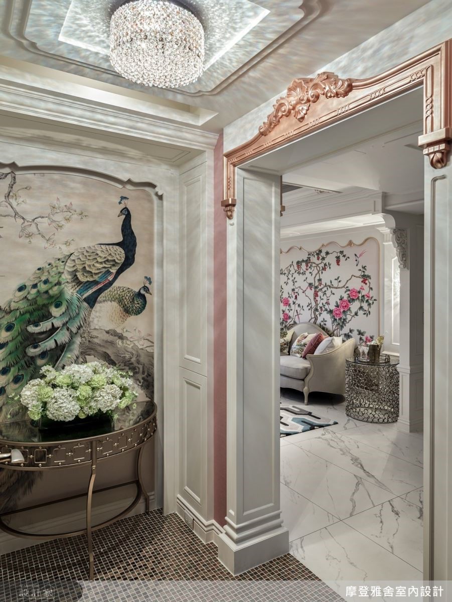 入口玄關以訂製孔雀壁紙展現主人尊貴身份，更於過渡框面雕琢圖騰與歐式柱頭，提升居家華麗感受。