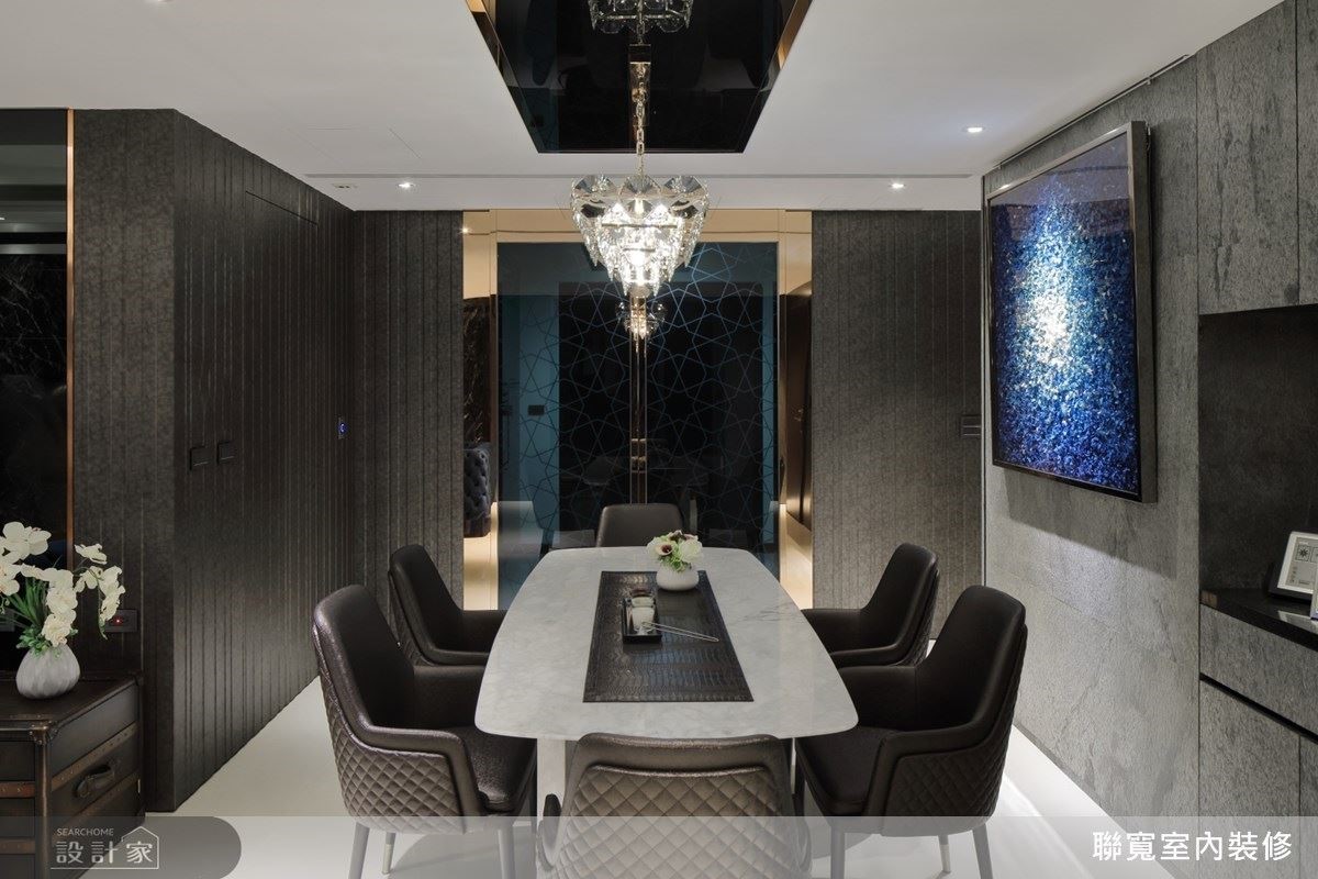 餐桌上方的水晶吊燈照出牆上畫作的顏色漸層，別具趣味。