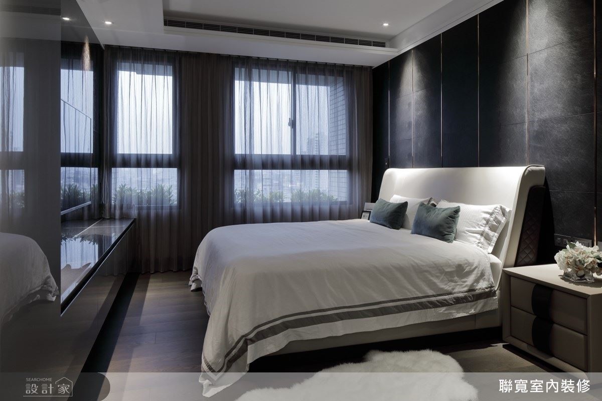 床尾電視牆石材反射自然光影的變化，在樸實無華的主臥空間裡營造低調的華麗感。