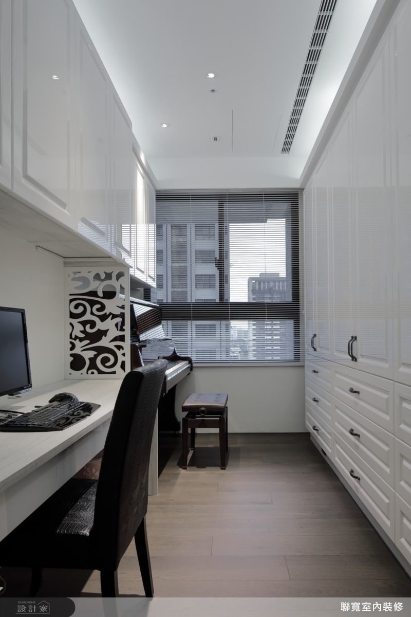 一字型的書房滿滿的收納牆，上方刻意不做滿，反而利用間接光源減少空間壓力。