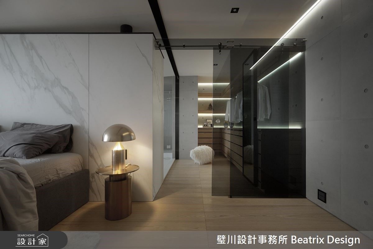 更衣間輕盈玻璃門，與牆面厚重水泥形成空間對比。