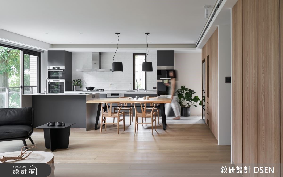 空間中的材質單純,色調以黑、白以及原木色為基調,牆面的收納櫃體以隱藏門設計使空間線條簡潔,延展的落地窗面賦予充沛採光。 空間中的材質單純,色調以黑、白以及原木色為基調,牆面的收納櫃體以隱藏門設計使空間線條簡潔,延展的落地窗面賦予充沛採光。