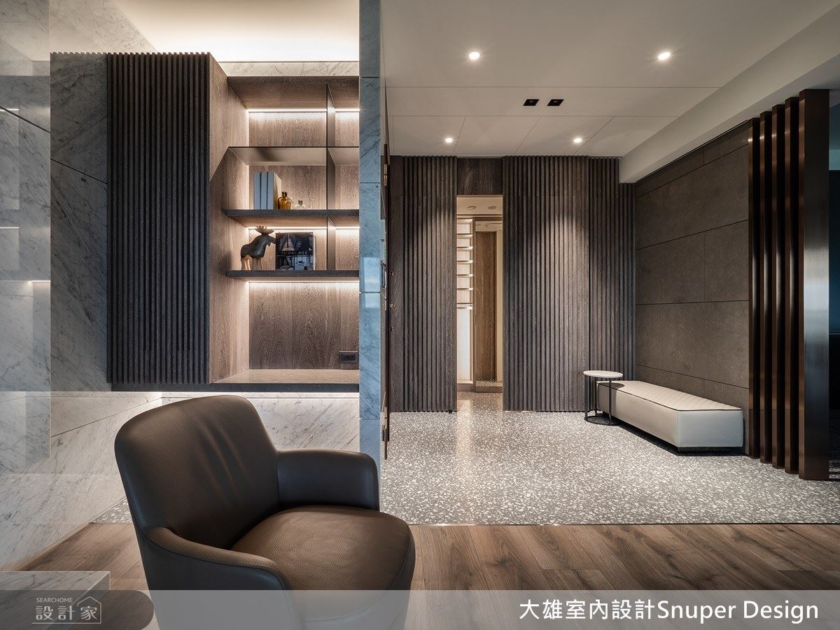 玄關地坪以灰階磨石子鋪陳，並搭配鍍鈦格柵，呈現義式精品效果。