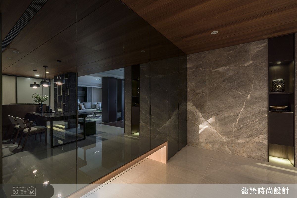 玄關鋪陳大面灰鏡，轉化櫃體成進門焦點，放大空間更締造氣派感受。